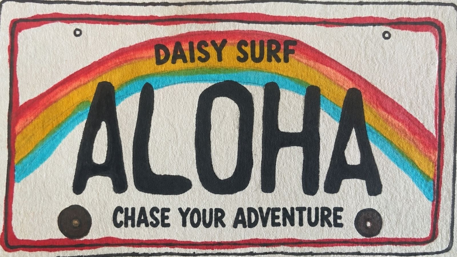 A hand-painted licence plate reading ALOHA, with
      DAISY SURF above a rainbow and CHASE YOUR ADVENTURE below