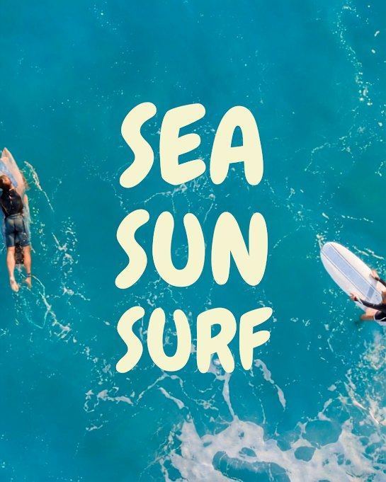 Sea, sun, surf &mdash; two surfers
        paddling out, seen from above